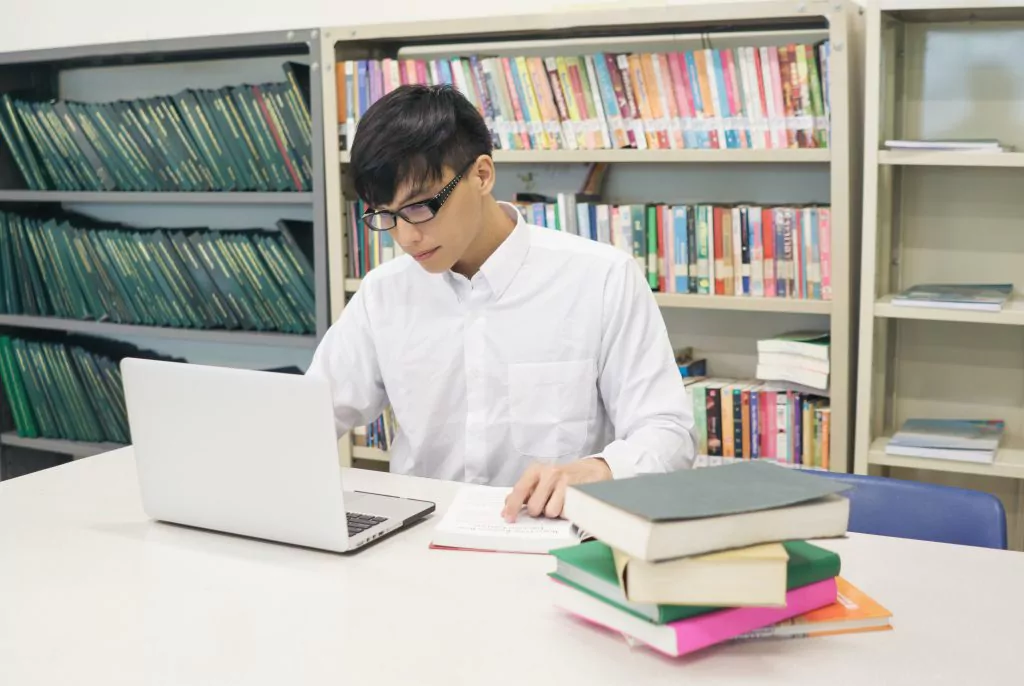 Arbeitnehmer am Lernen und Weiterbilden mittels Internet und Büchern. 