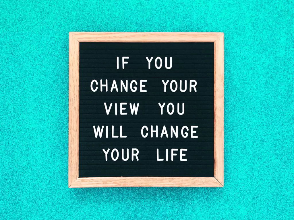 "If you change your view you will change your life" in weißen Blockbuchstaben auf schwarzem Bild gedruckt