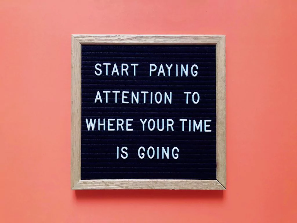 Tafel mit Aufschrift "Start paying attention to where your time is going" in Blockbuchstaben auf lachsfarbigem Hintergrund
