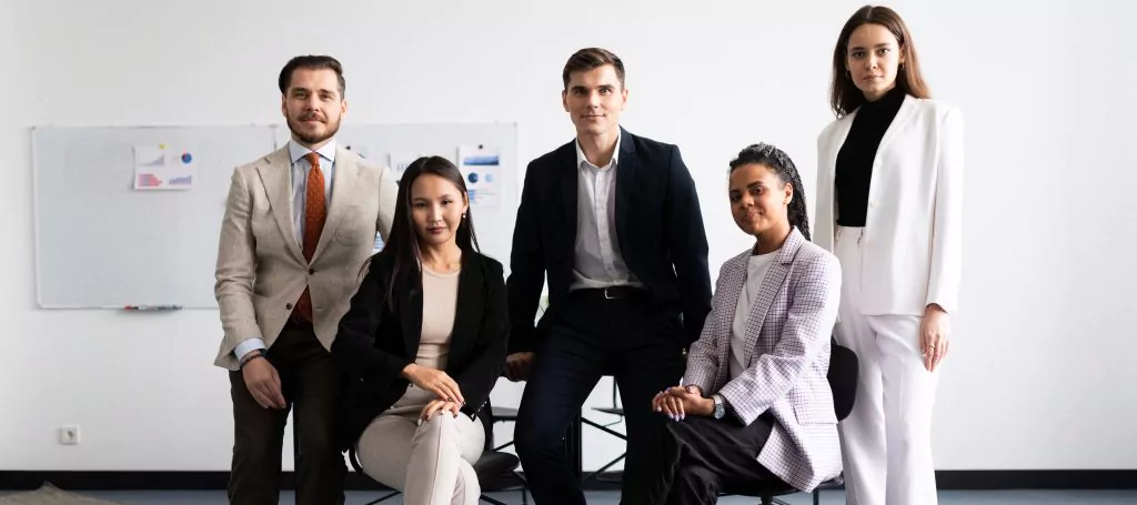 Team von drei Frauen und zwei Männern in Businessmode machen einen Gruppenfoto