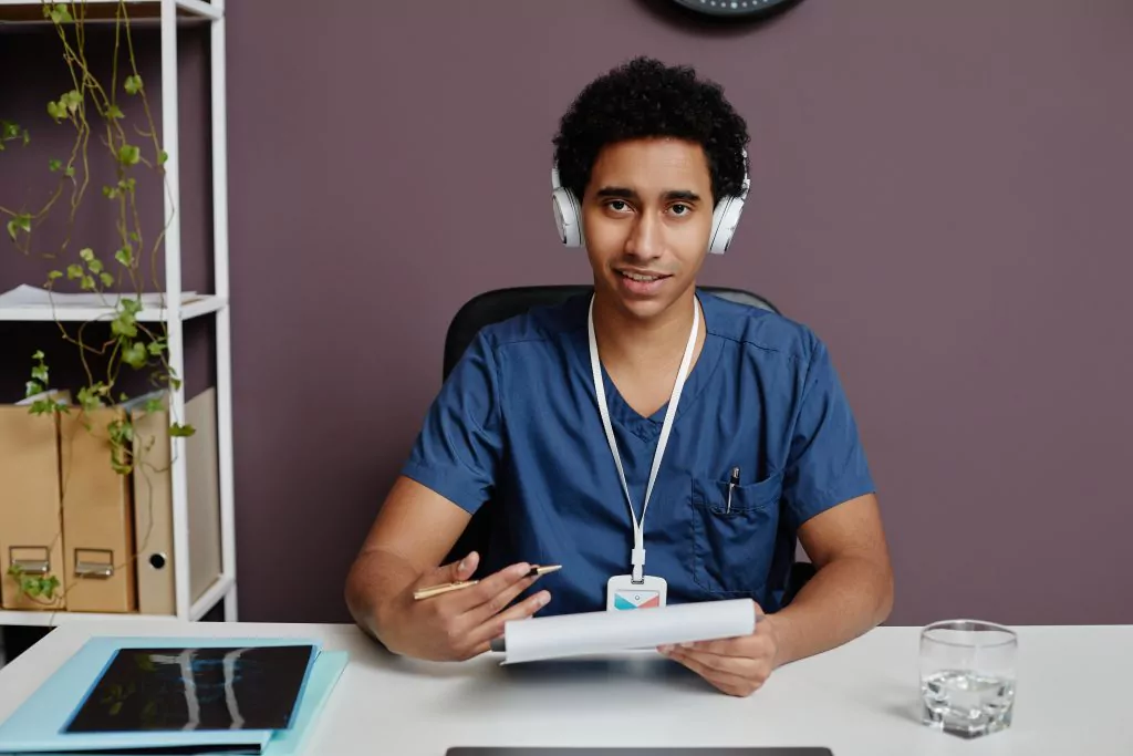 Mann mit Headset und Block sowie Kugelschreiber in der Hand